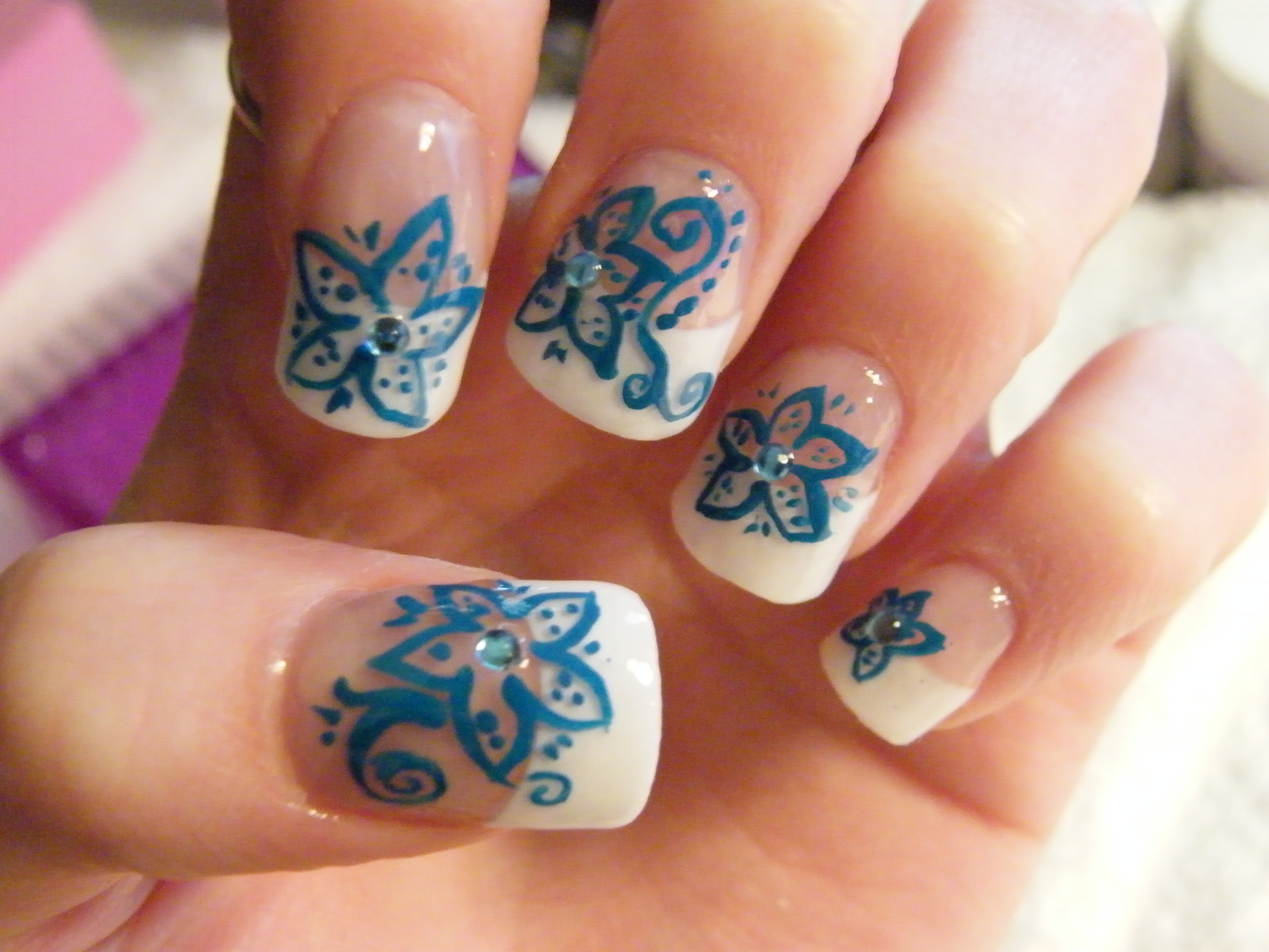 Acrylic nails with handpainted blue flowers and rhinestone